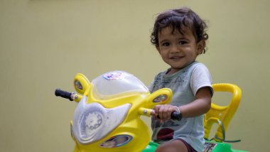 Küçük bir çocuk oyuncağıyla arabasıyla oynuyor ve kendini evinde mutlu hissediyor.