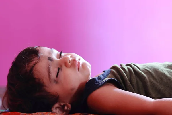一个漂亮的婴儿睡在房间里 房间墙壁上模糊的粉色 免费的孩子形象 — 图库照片