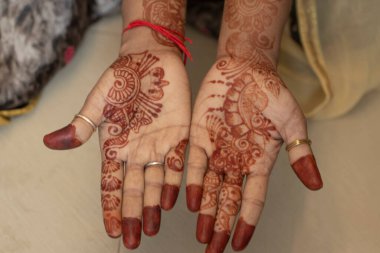 Mehndi tasarımı. Kırmızı renkli mehndi tasarımı, iki eli kız eli, holi mehndi tasarımı ve kadın eli deseni