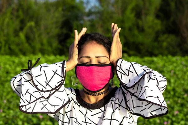 Стильная Женщина Носит Защитную Розовую Маску Лица Позирует Естественном Зеленом — стоковое фото