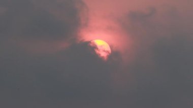 Gün doğumundan sonra kalın siyah yağmur bulutlarının ardında güneşi görmek.