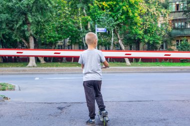 bariyer yakınında bir scooter üzerinde çocuk