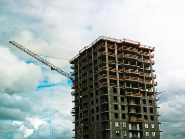 Bulutlu gökyüzüne karşı vinç ile bina