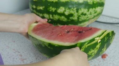 Kadın mutfakta bir karpuz dilim ve bir tabak içine parçaları atar