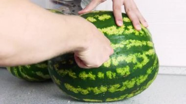 Adam mutfakta bir karpuz dilim iki yarısı halinde