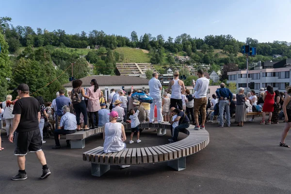 Åskådare sitter på ny rund bänk på den nya designade området stapferschulhaus Brugg på Morgenfeier den 4 juli på Jugendfest Brugg 2019. — Stockfoto