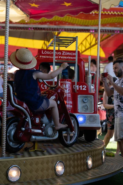 Barn med hatt på en motorcykel av en karusell på soliga eftermiddagen den 4 juli på Jugendfest Brugg 2019. — Stockfoto