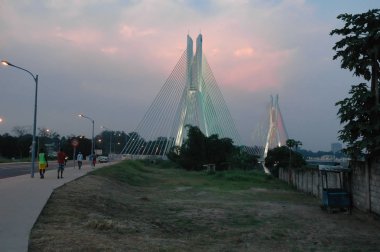 Brazzaville Kongo Aydınlanmış köprü Pont de la corniche, güzel gökyüzü ve afrika halkı yürüyüş ile alacakaranlıkta.