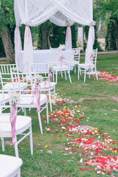 beautiful wedding or ceremony set up in garden, white chairs