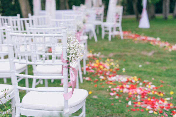 beautiful wedding or ceremony set up in garden, white chairs