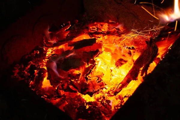 Bright big fire at night in a fire pit made of stones.