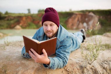 The researcher makes notes in a notebook lying on a quarry of white clay