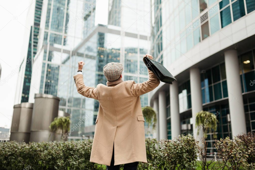 Office worker enjoys the end of the working week throwing his hands up