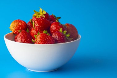 Mavi arka planda çilek ile beyaz plaka