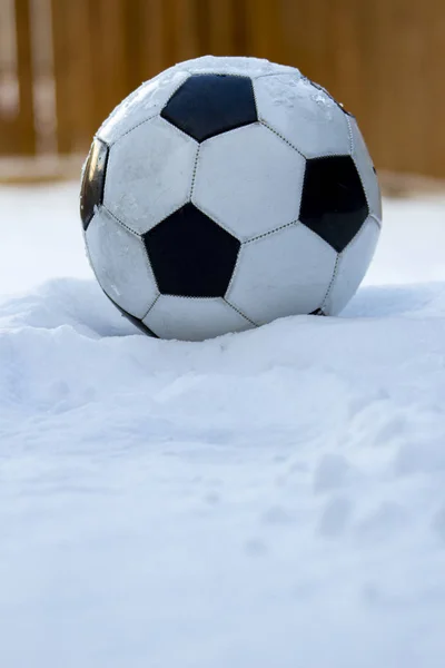 Voetbal, voetbal op sneeuw met een houten achtergrond — Stockfoto