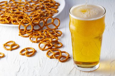 Beyaz arka planda bira ve krakerler