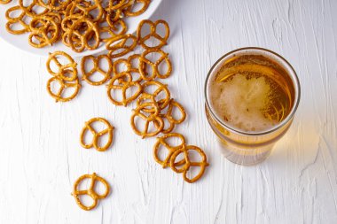 Beyaz arkaplanda bira ve simit üst görünümü