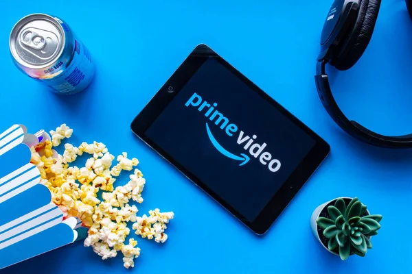 Calgary, Alberta. Kanada mı? Haziran 12020. Ekranda Prime Video logosu olan, patlamış mısır ve kulaklıklı bir iPad.