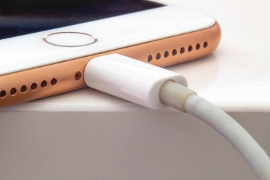 Calgary, Alberta. Kanada 5 Temmuz 2020. iPhone + 'nın görüntüsüne yakın çekim yap ve bir USB kablosuyla şarj et.