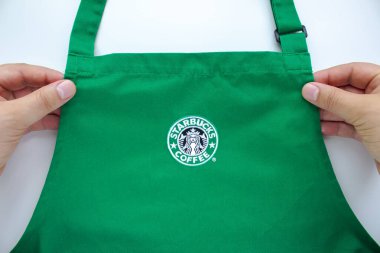 Calgary, Alberta, Kanada. Ağustos 1, 2020. Bir Starbucks çalışanı elinde markalı bir önlük tutuyor..