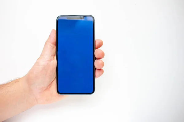Person Som Håller Smart Phone Med Blå Skärm Vit Bakgrund — Stockfoto