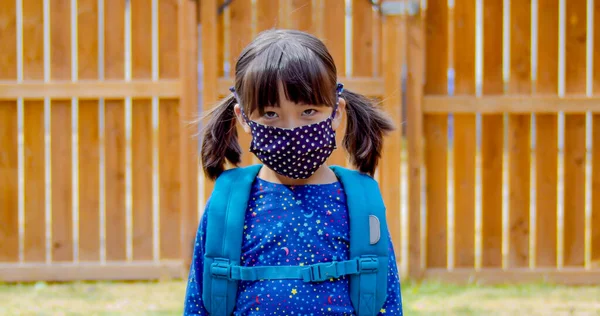 A kinder garden student wearing a facemask ready to go back to school.