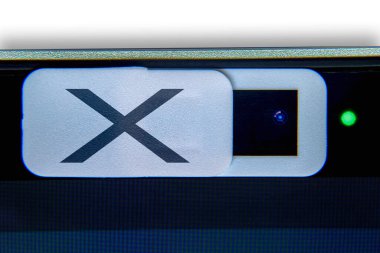 Üzerinde X harfi olan beyaz bir kamera gizlilik kapağı. Bir bilgisayar için kamera ağı örtüsü. Bilgisayar kamerasının özel hayatına sızma kavramı.