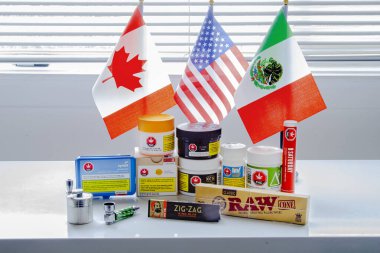 Calgary, Alberta, Kanada. Sep 18, 2020. ABD, Meksika ve Kanada bayraklı Kanada yasal keneviri markaları marihuana ot plastik kapları.