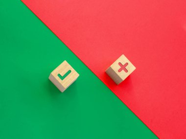 Yeşil ve kırmızı arka planda yanlış şarkı söyleyen bir çift tahta küp. Doğru ve yanlışın kavramı.