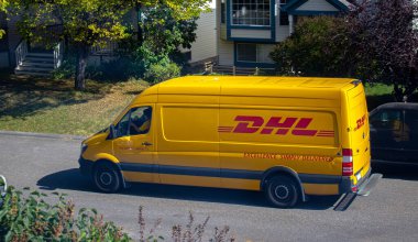 Calgary, Alberta, Kanada. Sep 21, 2020. Güneşli bir günde minibüs kullanan bir DHL çalışanı.