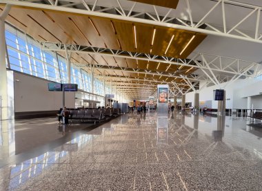 Calgary, Alberta, Canada. Sep 8, 2025. An airport departure hall featuring modern architecture, with high ceilings, reflective floors, and travelers waiting for their flights.