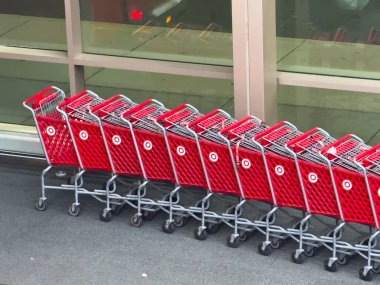 Chicago, Illinois, USA. Sep 11, 2025. A line of vibrant red Target shopping carts, with the brand's iconic bullseye logo, sit neatly outside a store, ready for customers.