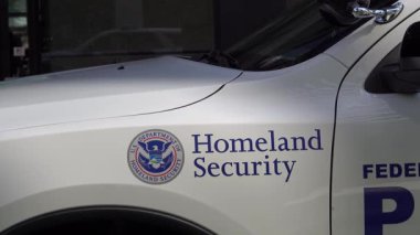 Chicago, Illinois, ABD. 21 Eylül 2025. Bir İç Güvenlik aracının resmi mührü ve yazısıyla arka planda bulanık bir şahsın net bir görüntüsü..