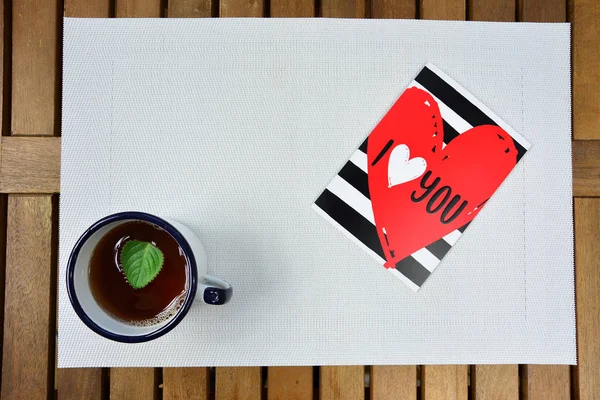 Happy Valentines Day. Valentines card with red hearts and tea cup.
