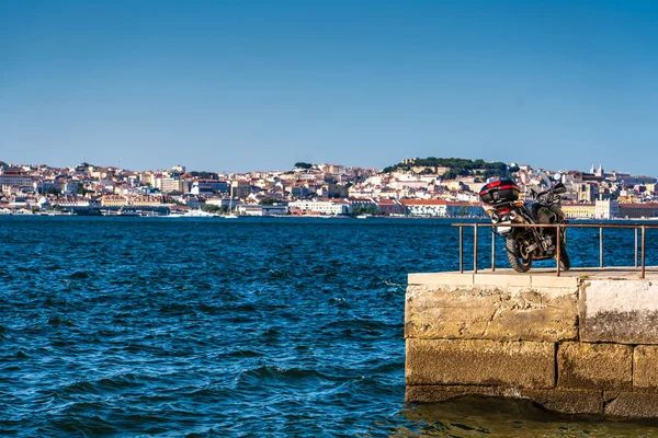 A motorbike parked at port. A concept of freedom, summer and holiday vacations on the beautiful Lisbon and the crystal clear blue sea.