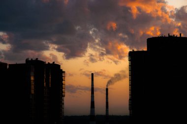 Gün batımı arka plan üzerinde iki gökdelenler arasında Borular