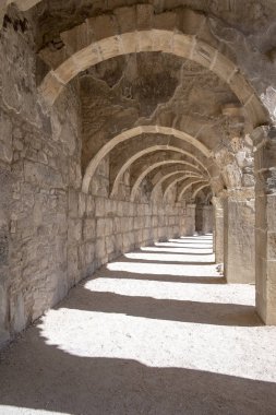Türkiye 'nin Antalya kentindeki Roma Amfiteatrı Aspendos' un kemerli koridorlarından birinin güzel perspektifi. Önplanda ışık efekti olan güzel, dokulu duvarlar..