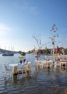 Gumusluk, Bodrum, Türkiye - 26 Eylül 2019: Yunanistan sınırı yakınlarındaki Bodrum Yarımadası 'nda Türkiye' nin Gumusluk köyündeki Ege kıyısındaki Yat ve restoranlar