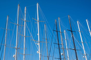 Mavi gökyüzü arkaplanındaki yat direklerini kapatın. Güzel rüzgarlı sularda yelken açmak için mükemmel bir güne hazırım.