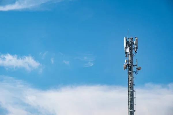 Cellular Base Station or Base Transceiver Station. Telecommunication tower. Wireless Communication Antenna Transmitter. 3G, 4G and 5G Cell Site with cloudy blue sky.