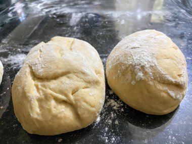 Ev yapımı mayalı ekmek hamuru ve mutfak tezgahında merdane.