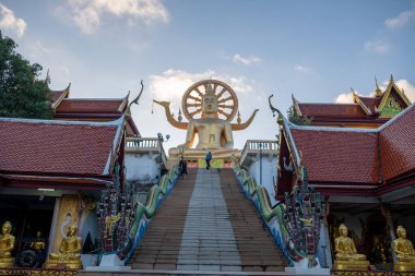 Tayland 'daki Koh Samui adasındaki Wat Phra Yai tapınağında dev ve altın bir Buda heykeli. Büyük Buda heykeli ve mavi gökyüzü