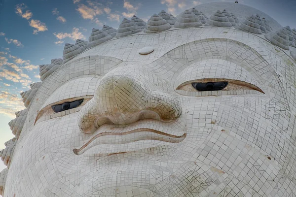 Close-up marble statue of a snow-white Big Buddha on the island of Phuket in Thailand. A giant Buddha figure made of marble bricks on Mount Nakaked in honor of the King of Thailand.