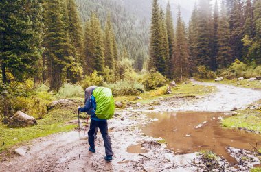 Dağlarda çamurlu bir yolda yürüyen adamlar