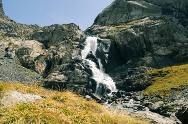 Dağlık bölgede bir şelale. Asya doğası.