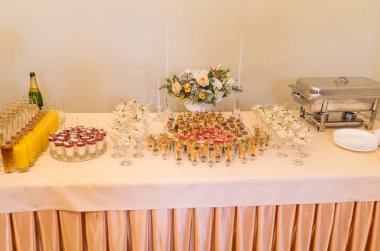 Düğün yemeği masası. Kanepeler, tatlı, meyve suyu, şampanyalar, çiçekler, salatalar ve festival masasındaki diğer atıştırmalıklar..