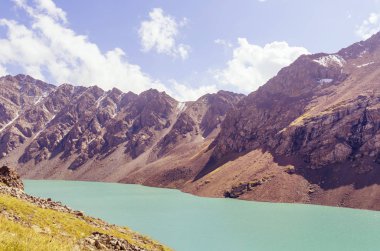Turkuaz gölün üzerinde güzel bir dağ zinciri..