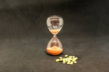 Kum saati zamanın sembolü, hapsa modern tıbbın sembolü. Vitaminler ömrünü uzatıyor. Kavram.