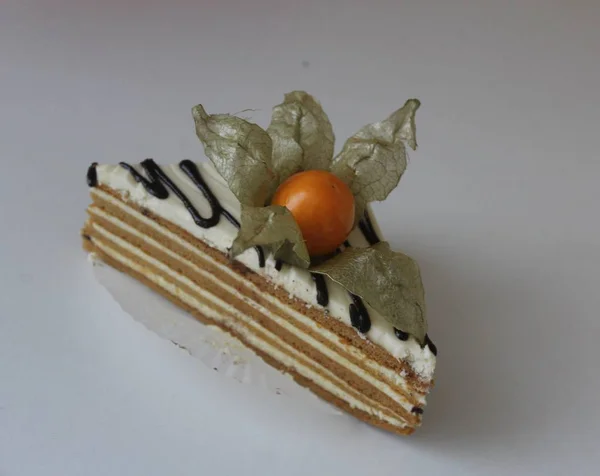 delicious piece of cake with chocolate and white cream. tasty cake with fezalis berry. mouth-watering piece of cake.