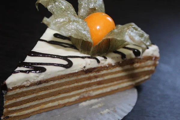 delicious piece of cake with chocolate and white cream. tasty cake with fezalis berry. mouth-watering piece of cake.